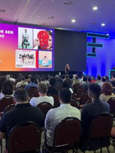 Auditório com um telão e imagens coloridas mostram o evento Marcas e Personagens, promovido pela Abral, em João Pessoa